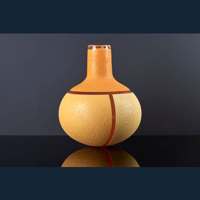 Mieke Groot (Alkmaar 1949), Unieke helderglazen flesvormige vaas. Met geometrische emaille decoratie in oranje en geel. Ontwerp en uitvoering in 2000. Signatuur 'Mieke Groot 2000'.
