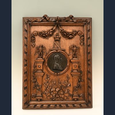 Een fraai gesneden houten lijst met in het midden een bronzen medaillon van Napoleon I