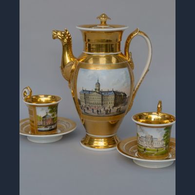 Twee Empire kop en schotels en een koffiepot, beschilderd met Hollandse stadsgezichten