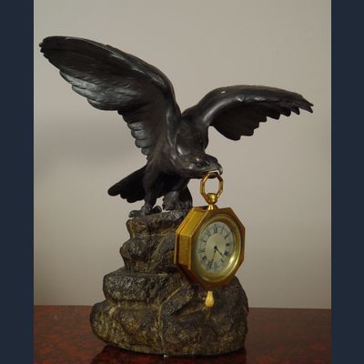 Een bronzen adelaar horlogestandaard met koetshorloge met kwartierrepetitie