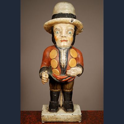 A multicoloured carved sculpture of a hunchback with remarkable buttons on his jacket, circa 1850