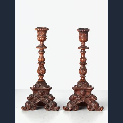 A small pair of Italian highly carved walnut single candlesticks, circa 1850