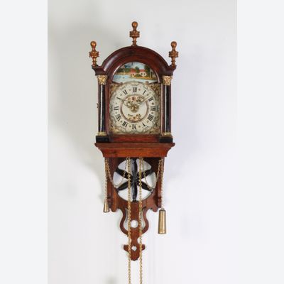 An attractive Dutch Frisian maddered oak striking alarm 'staartschippertje'wall clock, circa 1830.