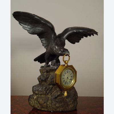 Een bronzen adelaar horlogestandaard met koetshorloge met kwartierrepetitie
