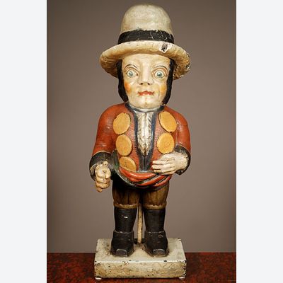 A multicoloured carved sculpture of a hunchback with remarkable buttons on his jacket, circa 1850