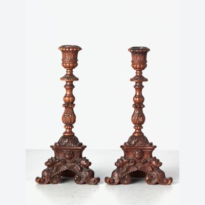 A small pair of Italian highly carved walnut single candlesticks, circa 1850