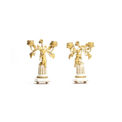 A cute pair of romantic small candlesticks featuring two small kids sitting on a white marble base