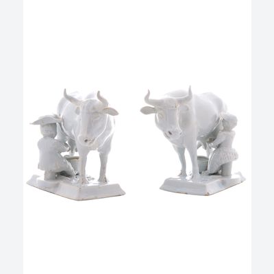 Un couple de vaches avec des trayeuses en faïence de Delft blanc.