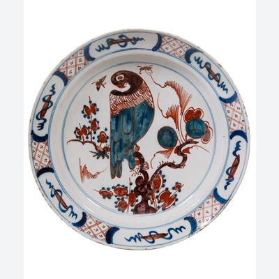 Ein polychromer holländischer Delft-Teller mit einem Papagei.