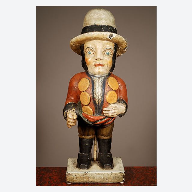 A multicoloured carved sculpture of a hunchback with remarkable buttons on his jacket, circa 1850