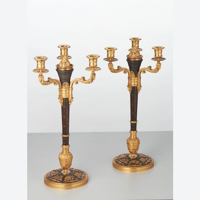 Ein seltenes Paar europäischer vierflammiger vergoldeter Bronze-Kandelaber im Stil des 'Directoire', um 1810 hergestellt.