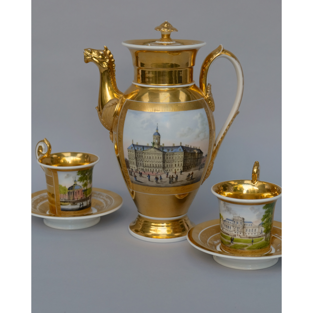 Twee Empire kop en schotels en een koffiepot, beschilderd met Hollandse stadsgezichten