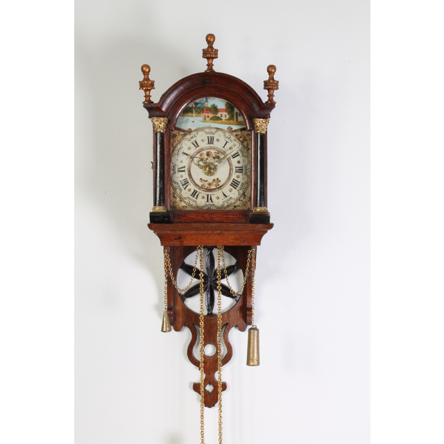 An attractive Dutch Frisian maddered oak striking alarm 'staartschippertje'wall clock, circa 1830.