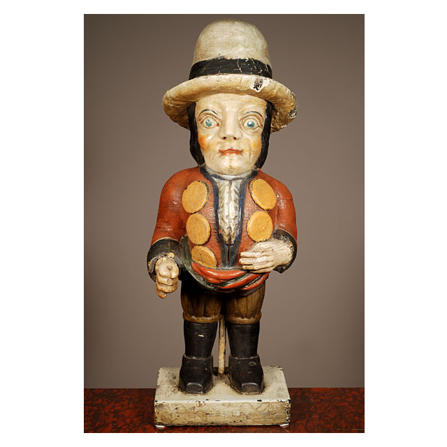 A multicoloured carved sculpture of a hunchback with remarkable buttons on his jacket, circa 1850