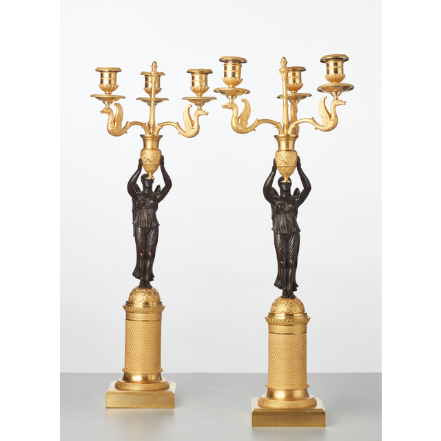 Een paar Franse vergulde kandelaars met gepatineerde bronzen engelen, circa 1820