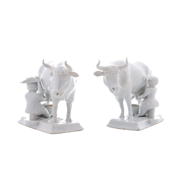 A Pair of White Cows with Milkers in Dutch Delftware