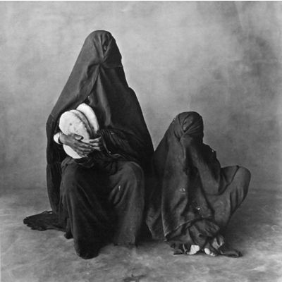Two women, wearing black, with bread, Morocco 1971